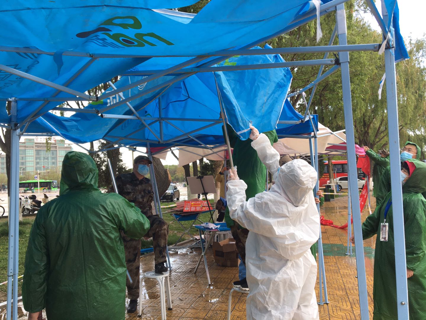 4月23日,在暴雨中的遮雨棚下工作